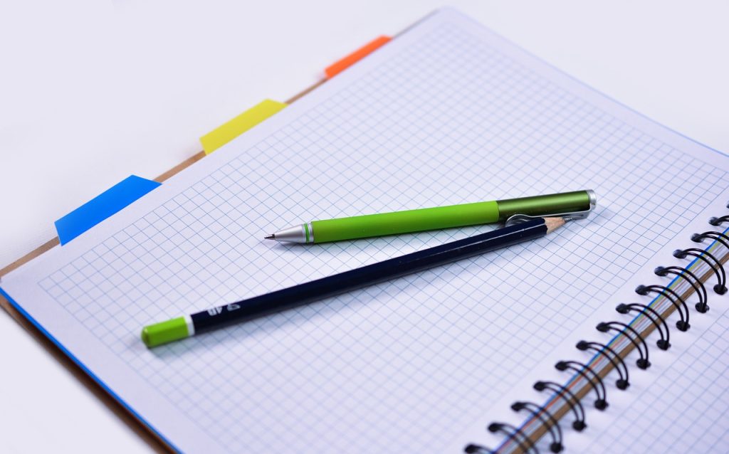 Fotografía de un cuaderno y dos lápices. Imagen de Monika en Pixabay. (Español) / Fotografia de um caderno e dois lápis. Imagem de Monika no Pixabay. (Português) / Photograph of a notebook and two pencils. Image by Monika on Pixabay. (English)