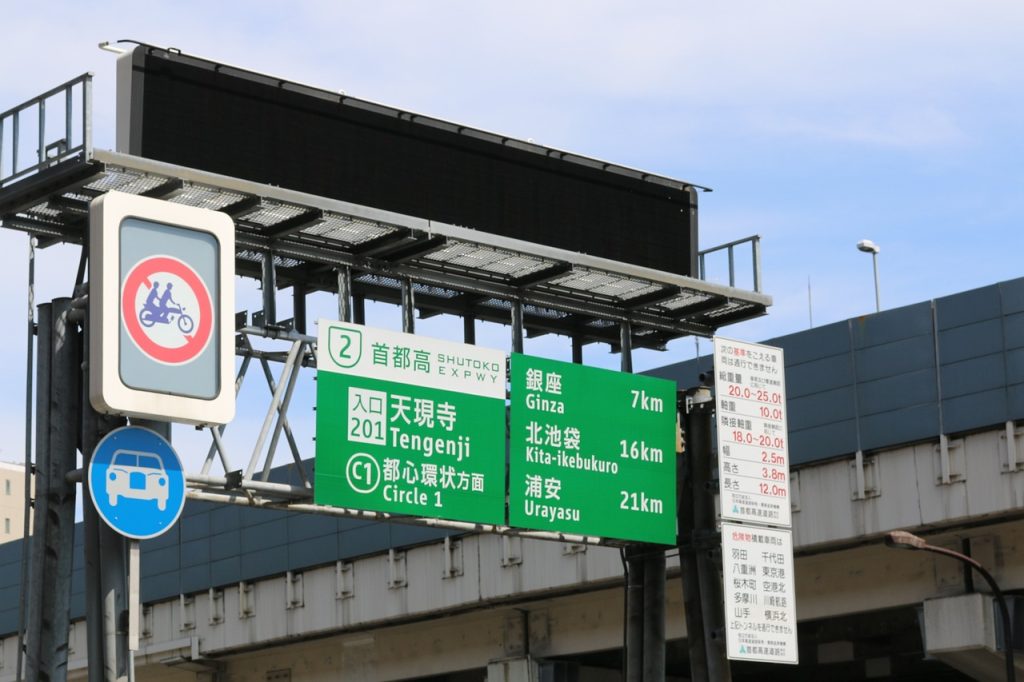 Fotografía de señalamientos de tránsito de una autopista en Tokio. Imagen de hoyas en Pixabay. (Español) / Fotografia de sinais de trânsito em uma rodovia em Tóquio. Imagem de Hoyas no Pixabay. (Português) / Photograph of traffic signs on a highway in Tokyo. Image by hoyas on Pixabay. (English)