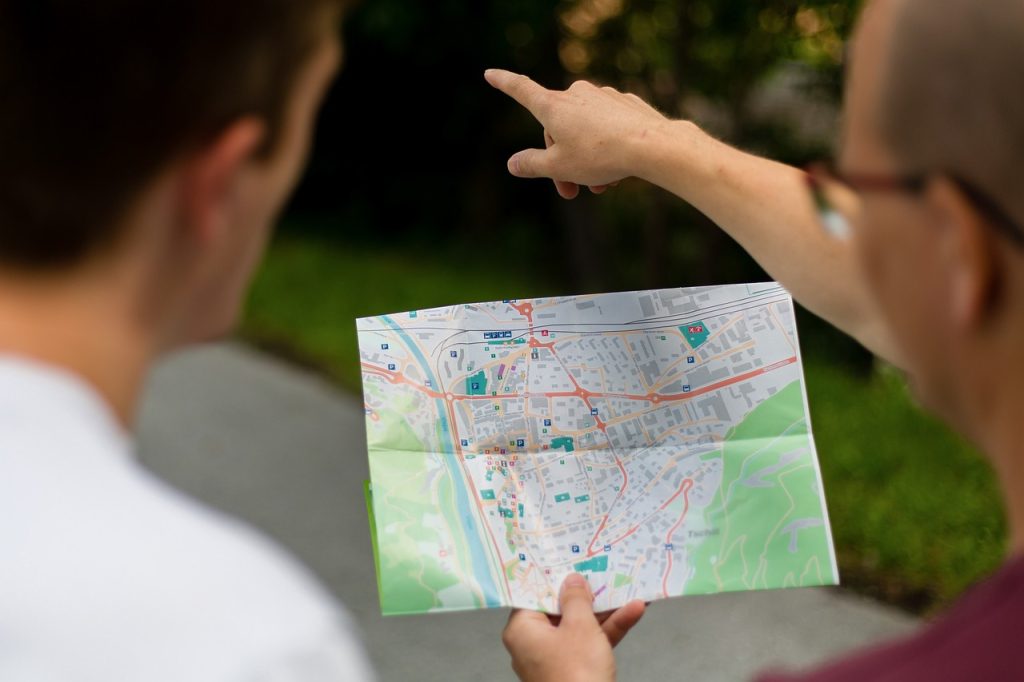 Fotografía de dos personas consultando un mapa. Imagen de Astrid Schaffner en Pixabay. (Español) / Fotografia de duas pessoas consultando um mapa. Imagem de Astrid Schaffner no Pixabay. (Português) / Photograph of two people looking at a map. Image by Astrid Schaffner on Pixabay. (English)